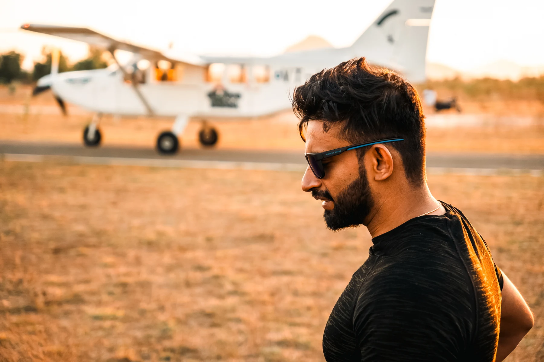Anubhav at the dropzone with the jump aircraft behind him