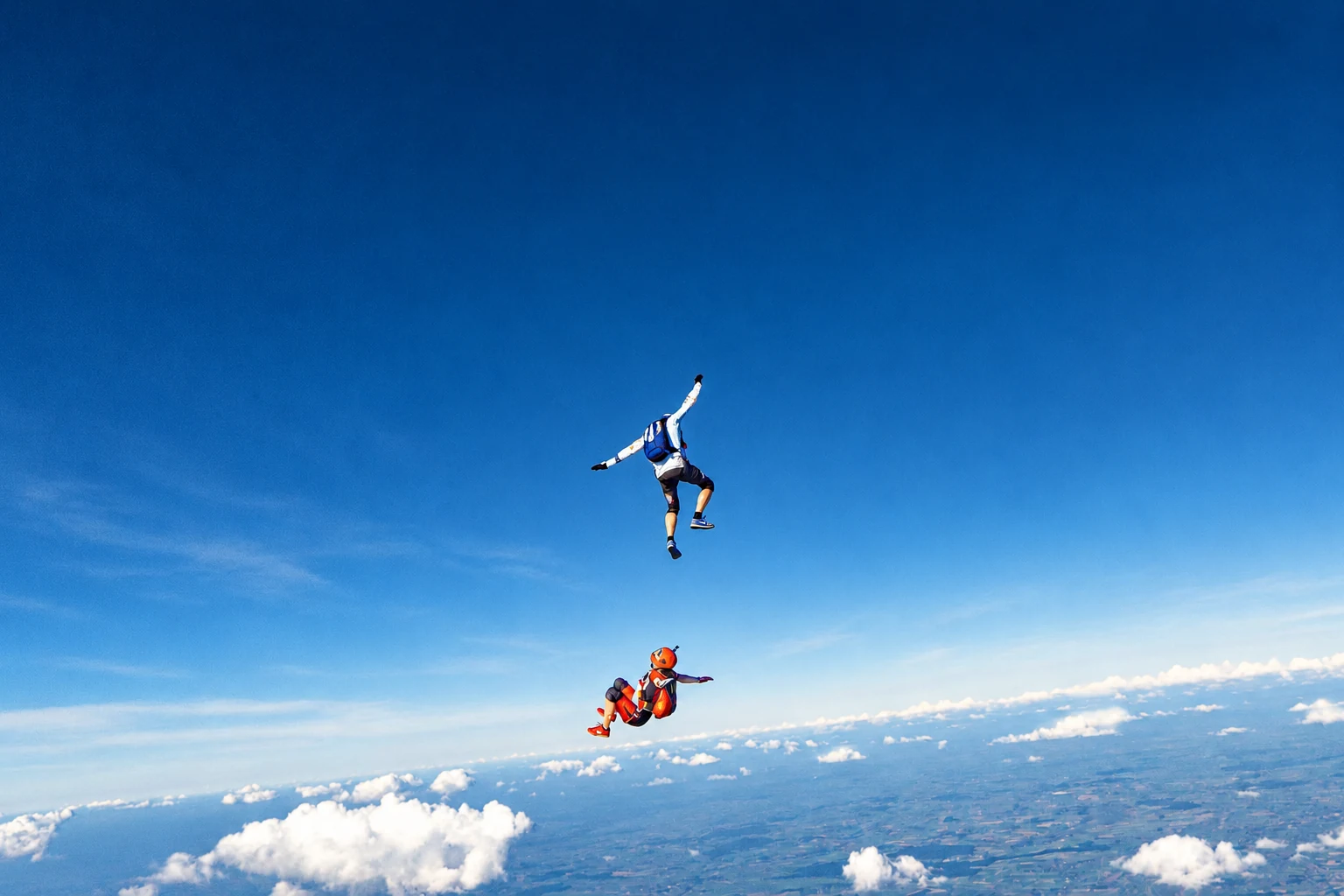 Two skydivers in open sky